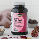 Close-up of Flora Red Beet Crystals powder in a spoon, highlighting the fine, bright red crystals ready to be added to beverages or dishes.